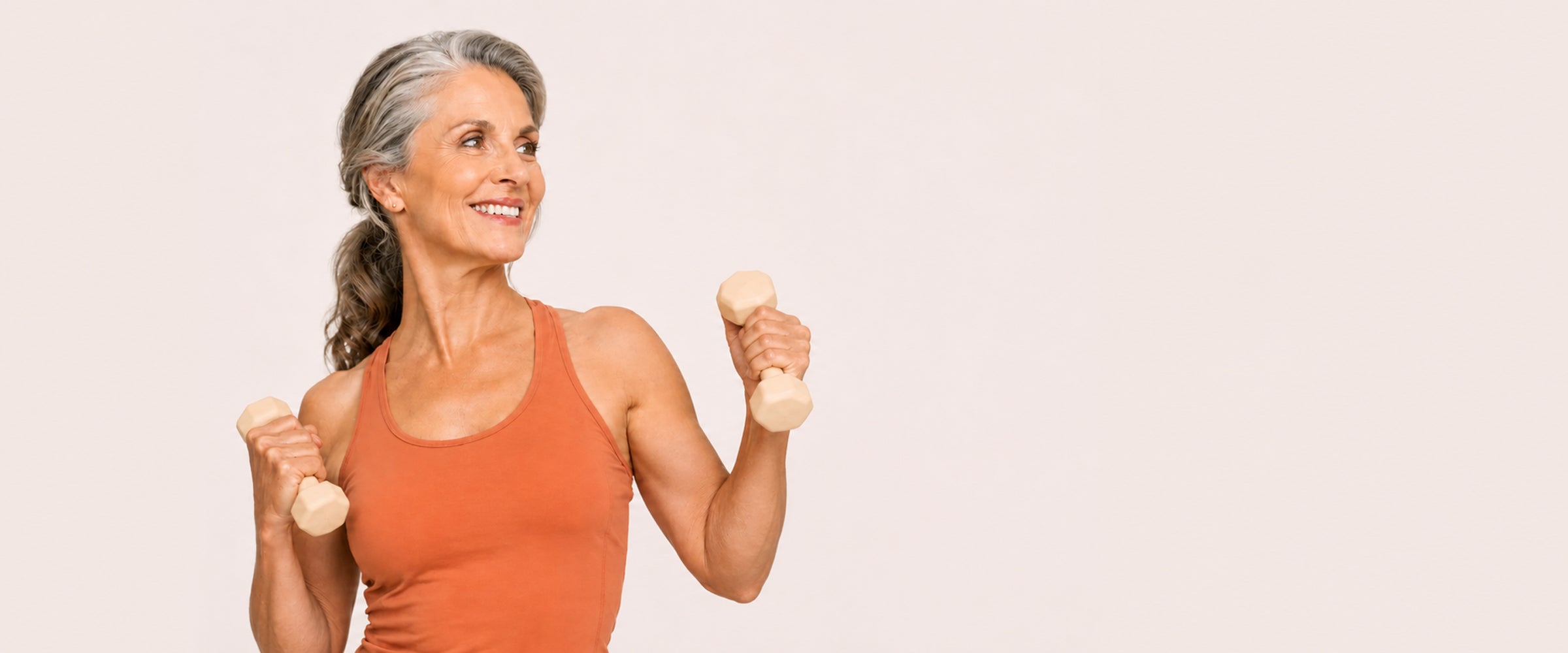 Mulher com 55 anos treinando com pesinhos com massa muscular forte
